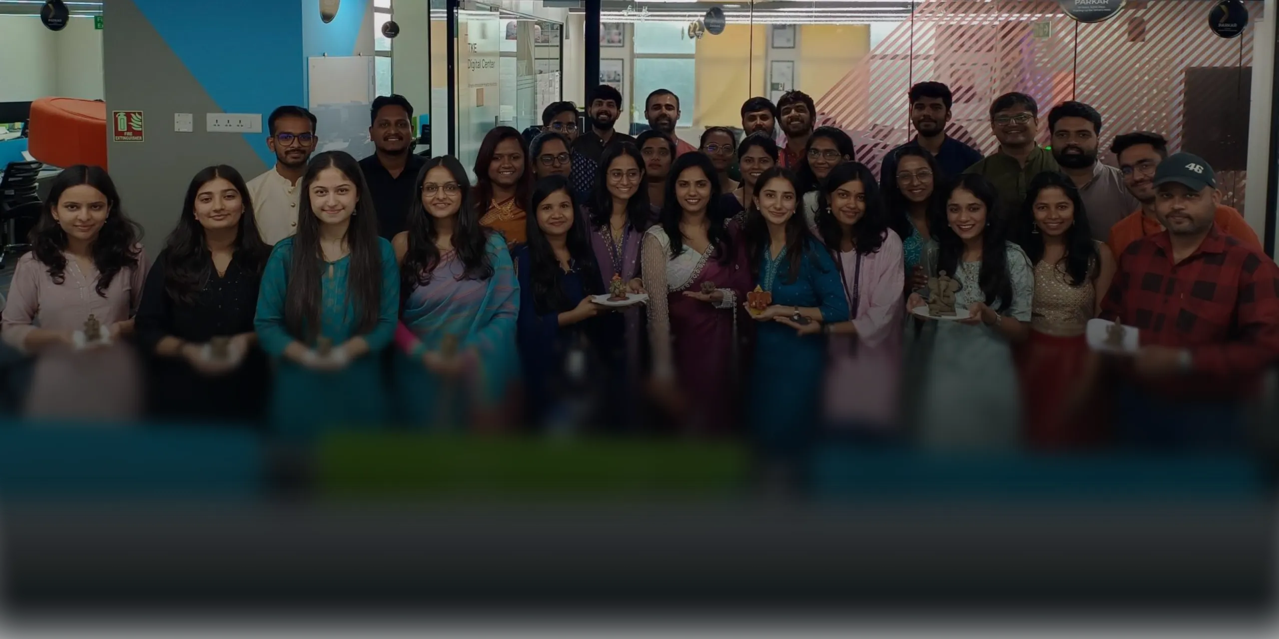 Group of diverse young adults standing indoors, smiling at the camera