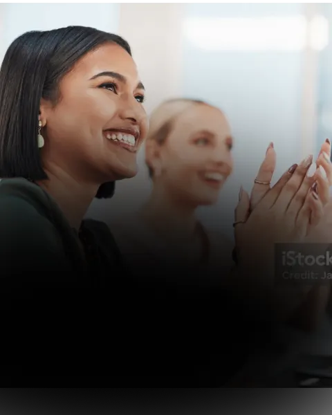 Two women smiling and applauding